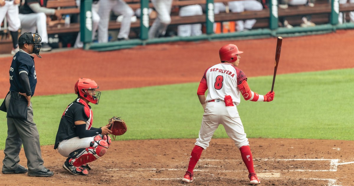 A baseball player at bat during a game, catcher and umpire behind home plate
