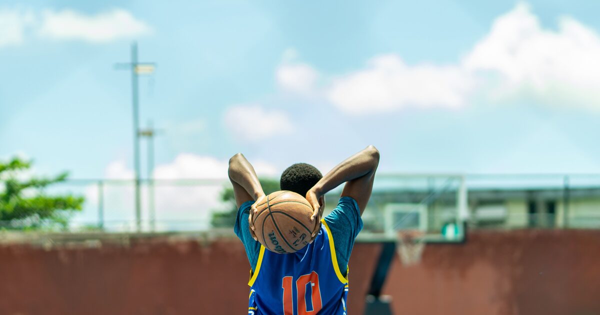 A young basketball player practising on an outdoor court