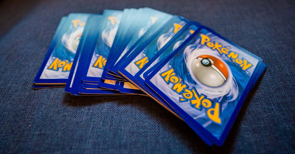 An overhead view of a spread of collectible trading cards on a grey backdrop